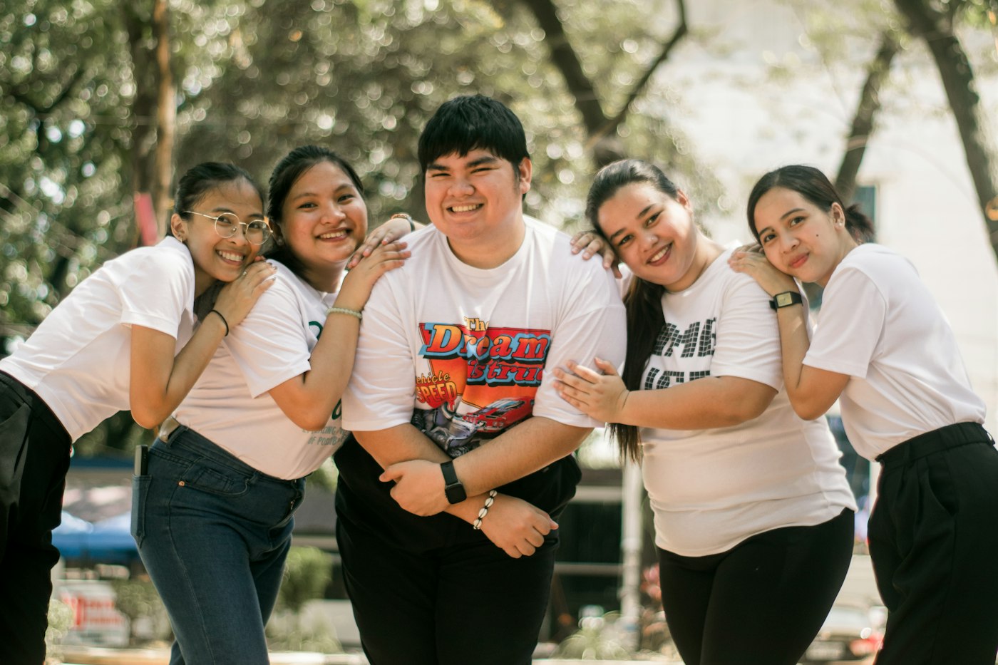 Un groupe d'amis souriants, bras dessus bras dessous